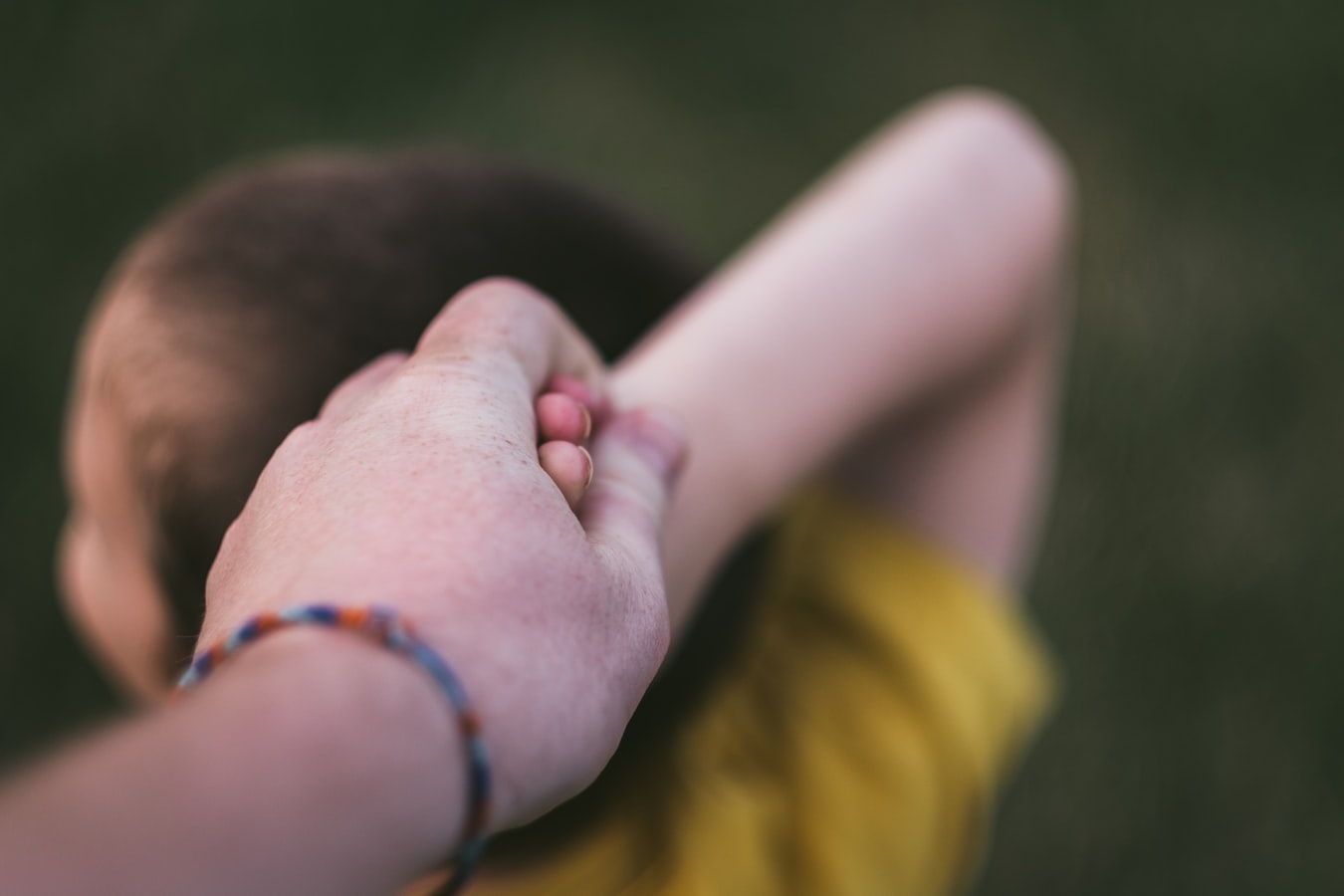 Un enfant retenu par le bras par un adulte
