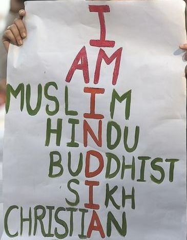 Une manifestante brandissant une inscription avec les principales religions de l'Inde.