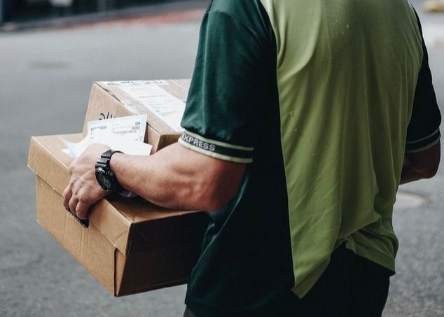 Un homme livrant des produits emballés dans des cartons.